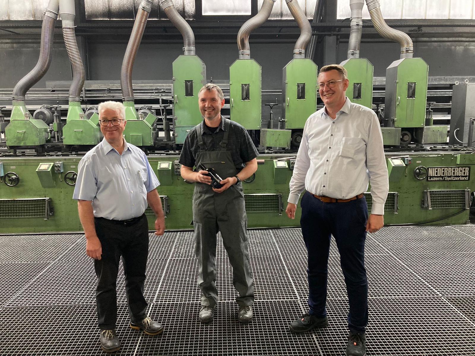 Lothar Schmid (Produktionsleiter Schleiferei, links) und Ralf Stempel (Betriebsleitung, rechts) gratulieren Viktor Klatt zum 25-jährigen Betriebsjubiläum.